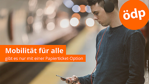 Mann mit Kopfhörern steht am U-Bahngleis und schaut auf das Smartphone. Im Hintergrund fährt ein Zug ein. Oben rechts das ÖDP-Logo. Links der Schriftzug über dem Bild "Mobilität für alle gibt es nur mit einer Papierticket-Option"