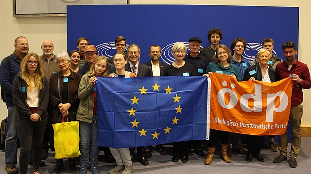 20 Personen vor blauem Hintergrund. Vordere Reihe hält eine EU- und eine ÖDP-Flagge.